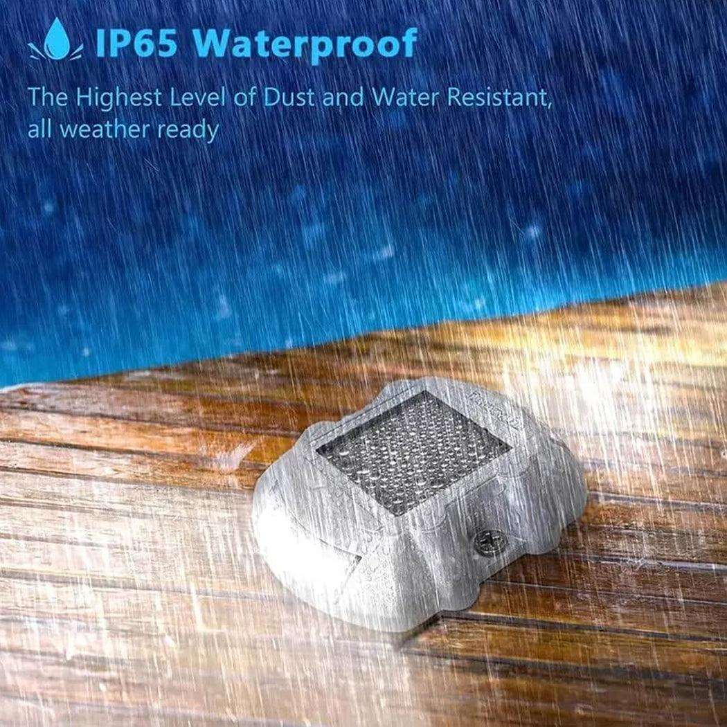 Driveway deck marker light displayed on a wooden surface during heavy rain—featuring IP65 waterproof protection, high dust resistance, and rugged construction for reliable outdoor performance in all weather conditions.