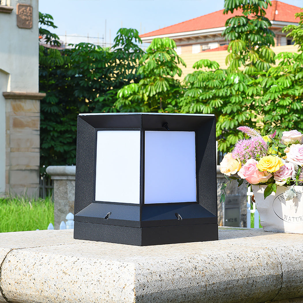 Square solar pillar light with frosted acrylic panels and a sleek black aluminum frame, featuring an integrated top-mounted solar panel. Offers triple-color LED customization—switch between daylight, warm white, and cool white using the included remote control. Dual power options allow solar charging for 8–10 hours of nightly illumination, or wired installation with an E27 bulb for consistent brightness, also remote-controlled. Designed for modern outdoor pillars, gates, and patios.