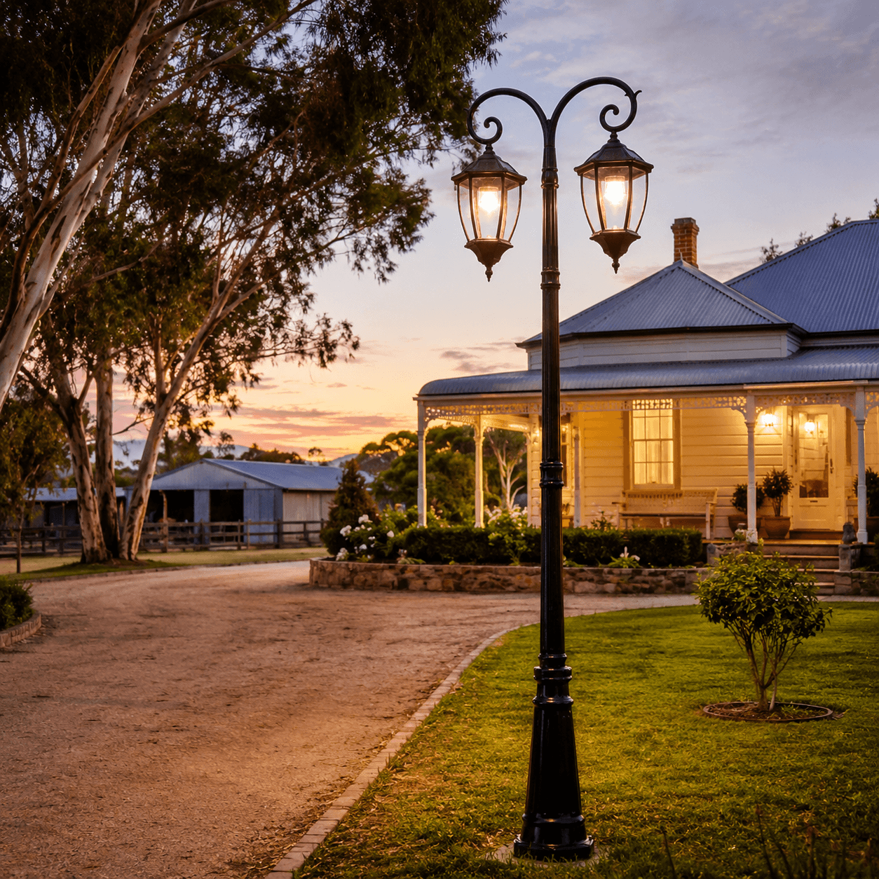 Antique black Double Head solar Post Light illuminating a rural driveway and front garden entry of a classic Federation-style home at dusk.