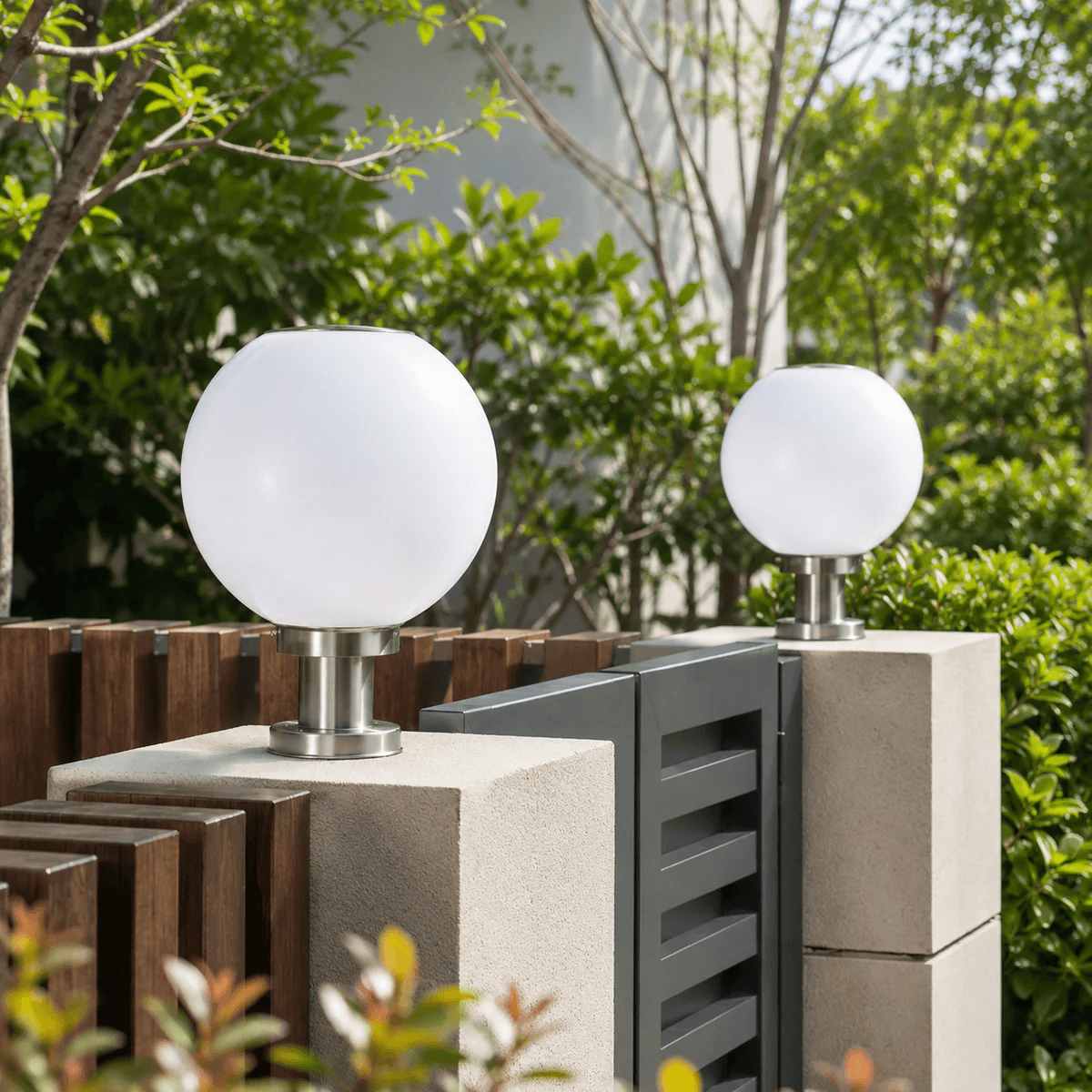 Two round solar globe column light fixtures mounted on concrete gate pillars next to a timber fence in Australia