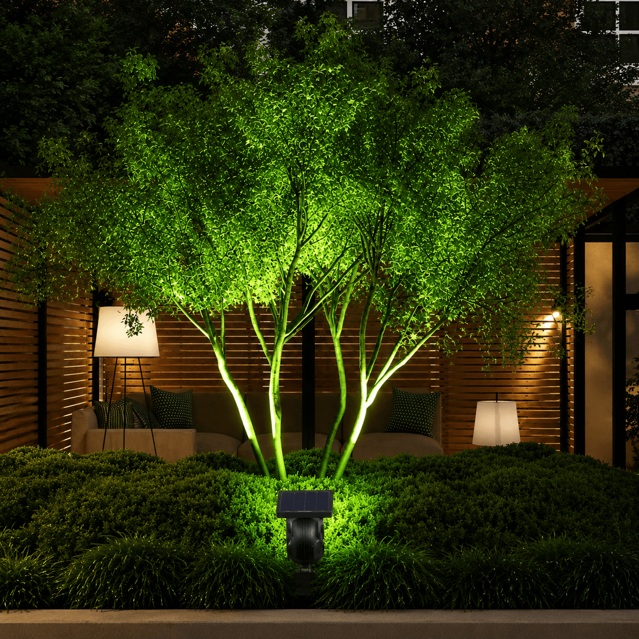 Single colour solar spotlight outdoor unit casting a bright green glow up a patio garden tree in an Australian backyard courtyard.