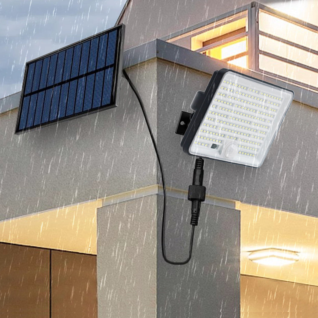 Solar powered wall light waterproof IP65 design mounted outside on a house wall during heavy rain.