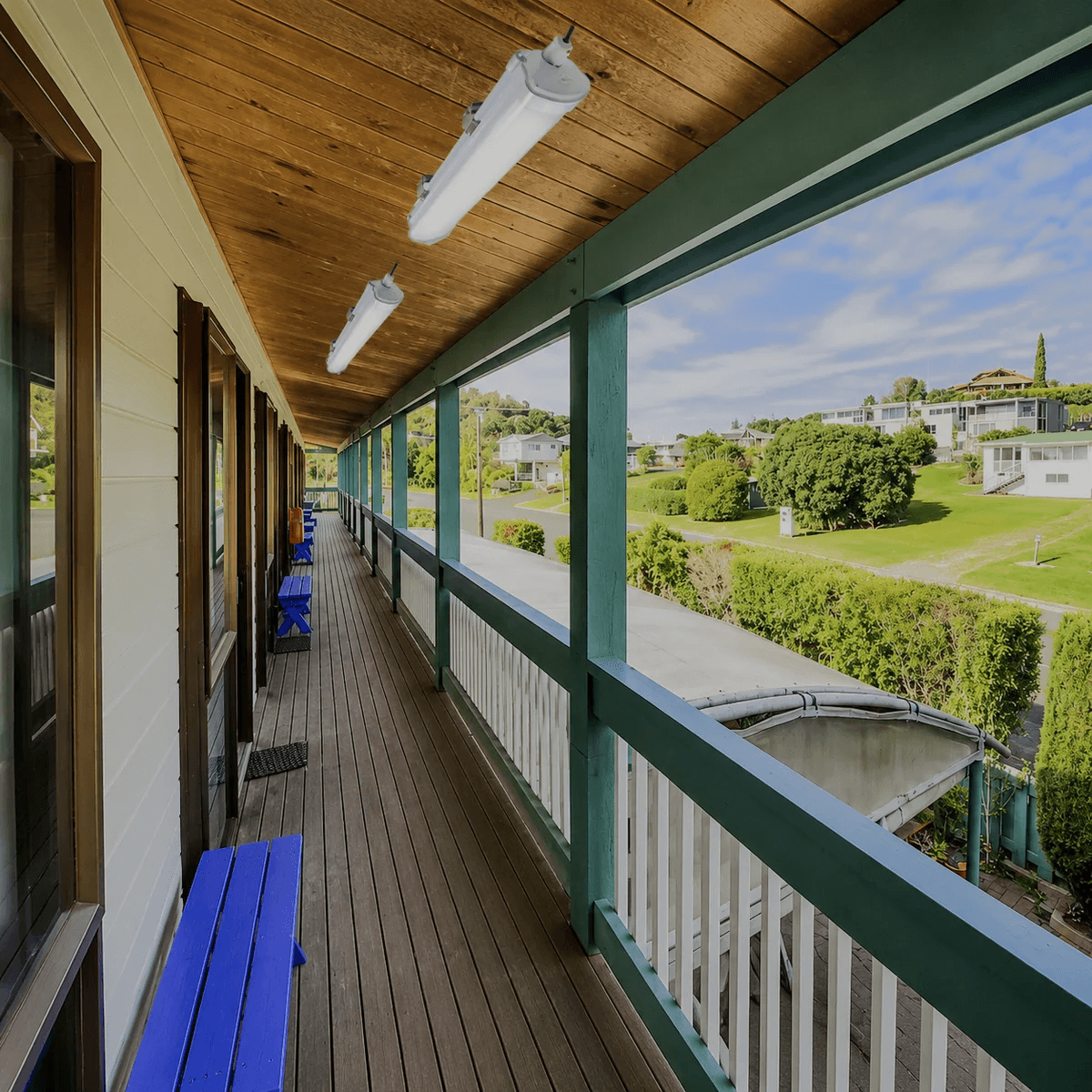 Dual solar tube ceiling light fixtures installed under a wooden outdoor veranda roof as weatherproof bar lights.