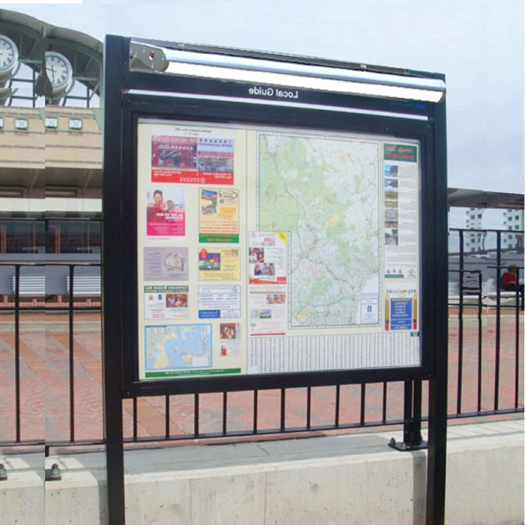 Outdoor public information board labeled 'Local Guide' illuminated by a solar-powered LED light mounted above. The fixture provides consistent lighting for maps and community notices, enhancing nighttime visibility. Its solar panel and weather-resistant design make it ideal for transit hubs and public squares, supporting energy-efficient urban signage