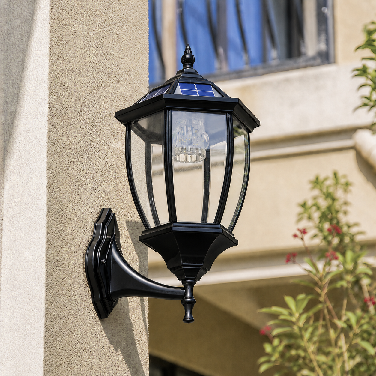 Classic solar coach lantern installed as a traditional solar wall sconce on an exterior stucco pillar showcasing the clear glass and antique design.