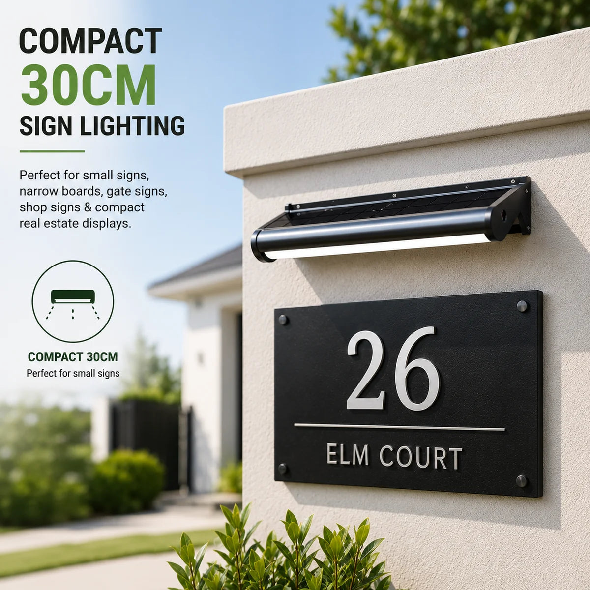 A compact 30cm outdoor solar sign lighting fixture mounted above a house number plate on a modern brick wall.