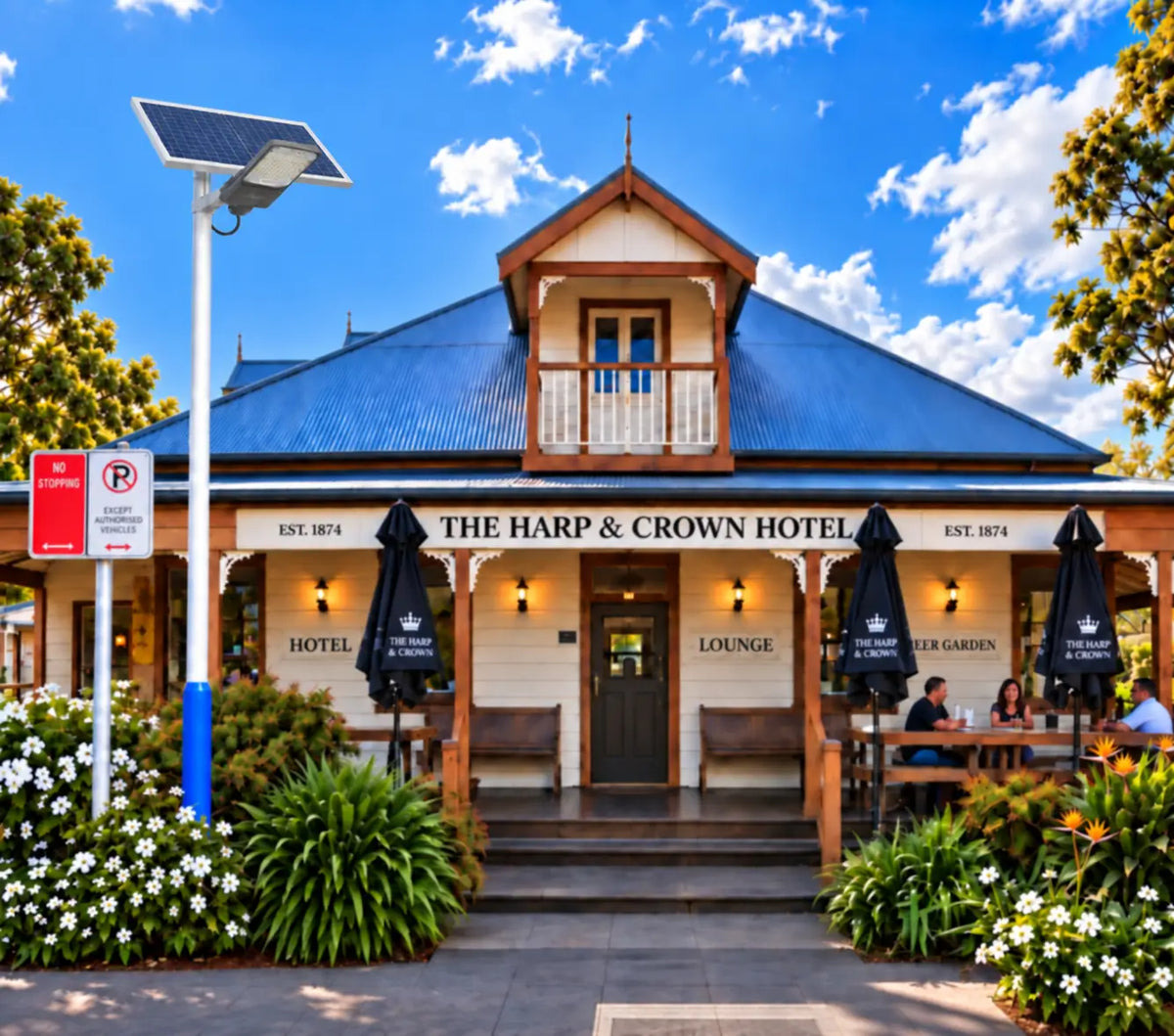 A Rainman G60 commercial solar street light pole-mounted outside a historic Australian hotel and pub storefront, providing off-grid street parking and front entrance security illumination for outdoor dining areas.