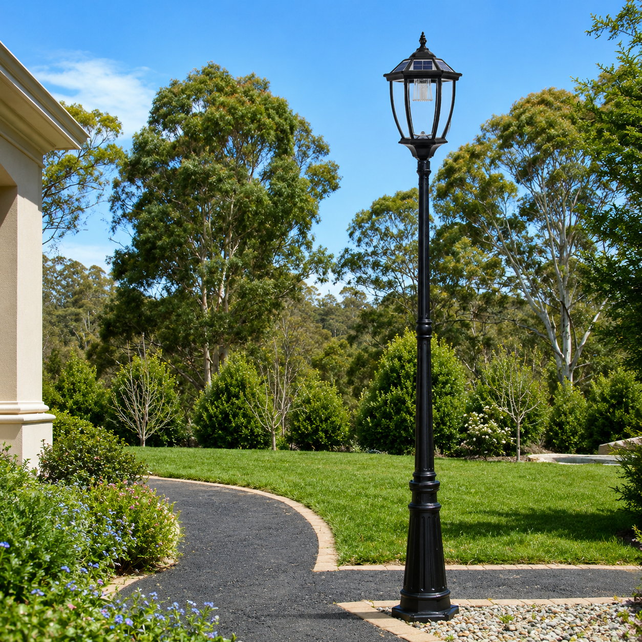 A black victorian solar post light standing tall as a solar garden lamp post along a garden path, showcasing the antique solar lantern design with built-in solar panels during the day in Australia.