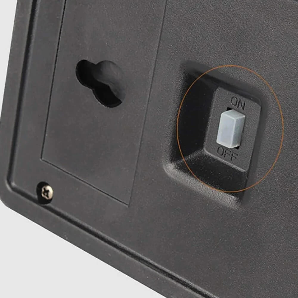 Close-up view of the back panel of a solar wall light highlighting the manual on off power switch and keyhole wall mount slot.
